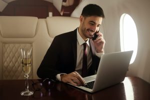 Billionaire or rich businessman flying first class and working on plane